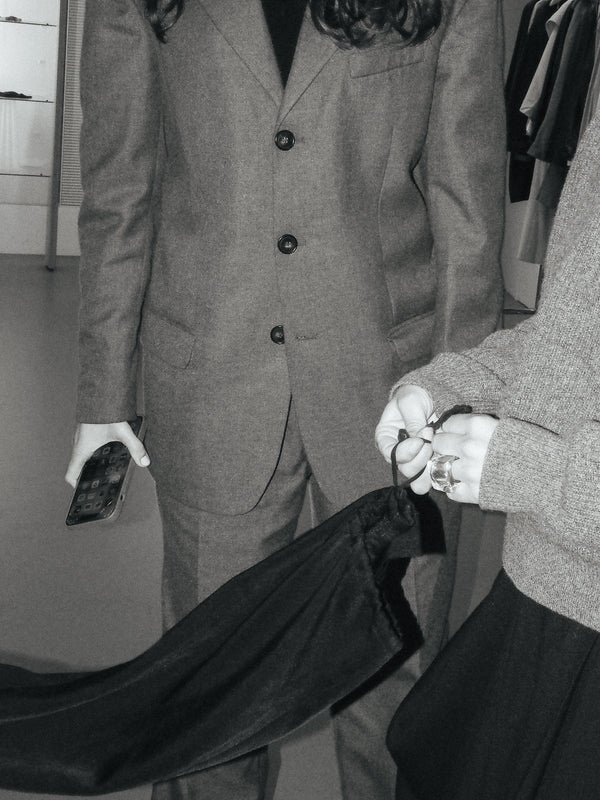 two people standing with one person holding a black skirt