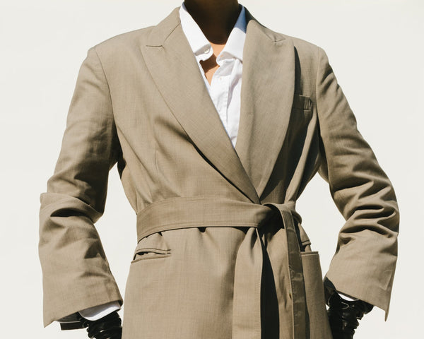 side profile of a model wearing a white shirt with a pale pink top layered over it